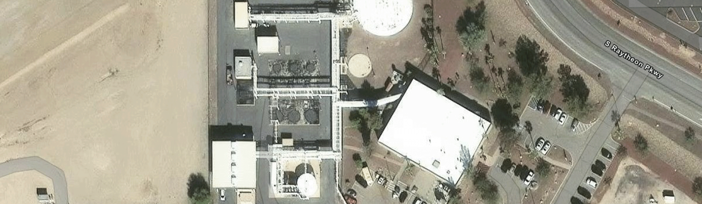 Satellite photo of an industrial complex at U.S. Air Force Plant 44, showing facility buildings, specialized machinery, parking lots, and adjacent roads from directly above