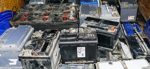 Pile of used car batteries collected for recycling or disposal.